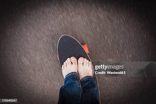 germany, north rhine westphalia, duesseldorf, mature man standing on skateboard - pasear en coche sin destino fotografías e imágenes de stock