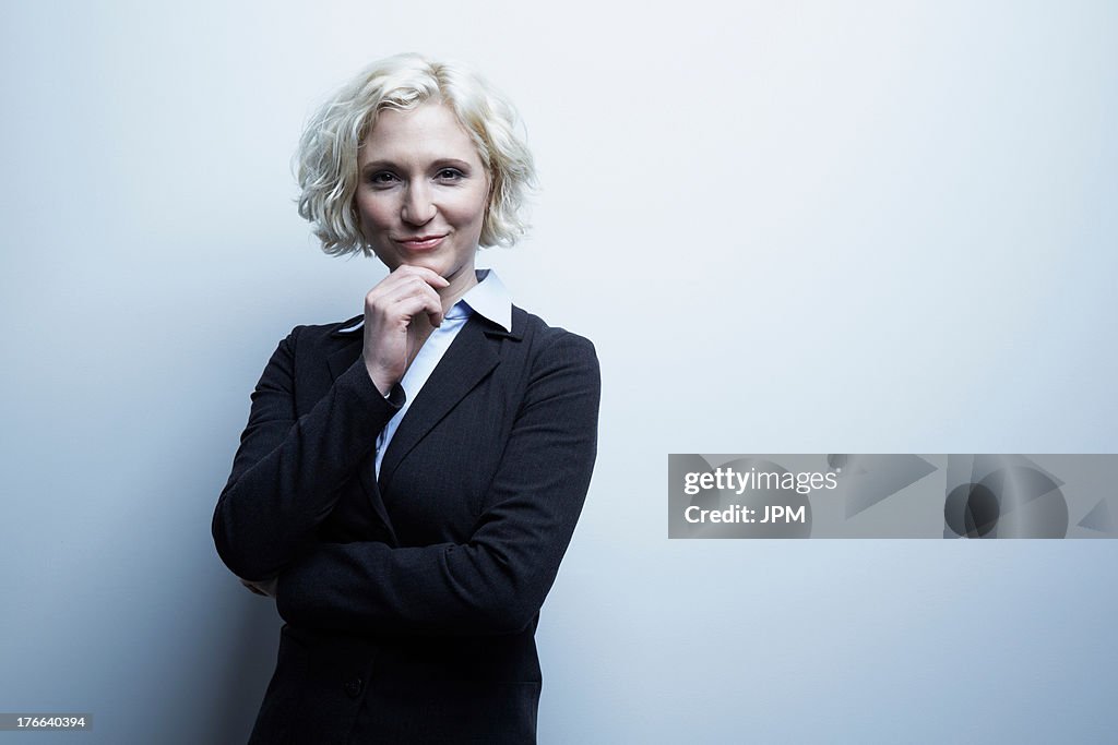 Studio portrait of businesswoman with hand on chin