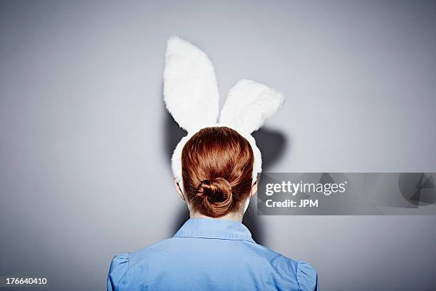 back view of young woman wearing bunny ears - bunny girl costume fotografías e imágenes de stock