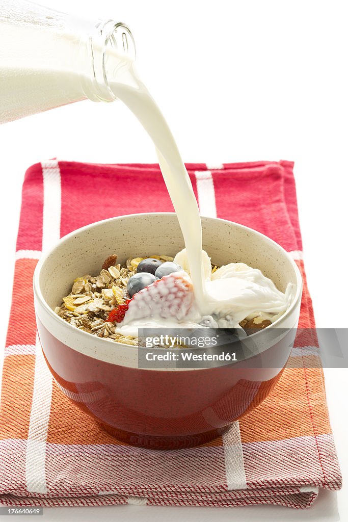 Breakfast bowl of cereals with blueberry, strawberry, milk and yogurt