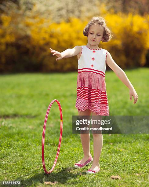 young girl rolling hula hoop in park - hoop rolling stock pictures, royalty-free photos & images