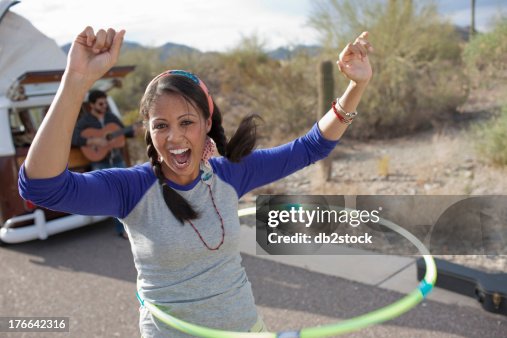 Young woman dancing with plastic hoop on road, portrait Young woman dancing with plastic hoop on road, portrait