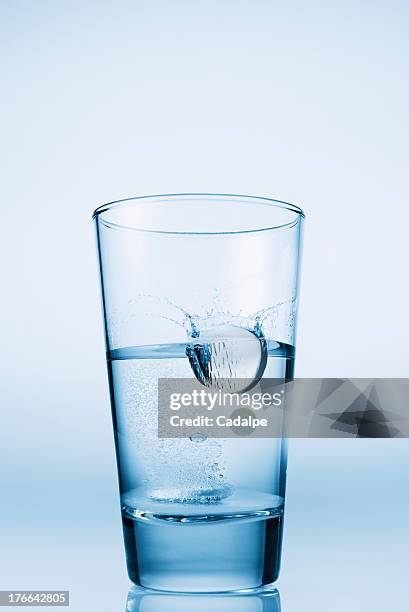 tablet falling in glass of water - cadalpe stock pictures, royalty-free photos & images