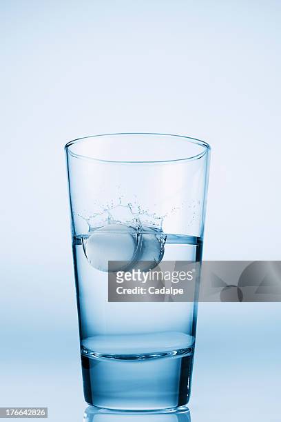 tablets falling in glass of water - cadalpe stock pictures, royalty-free photos & images