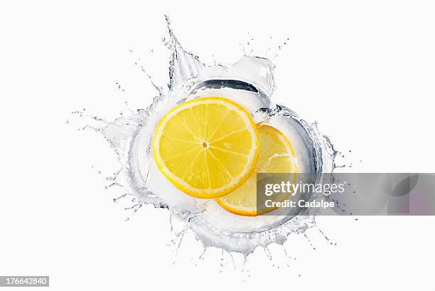 two slices of lemon splashing in liquid - cadalpe stock pictures, royalty-free photos & images