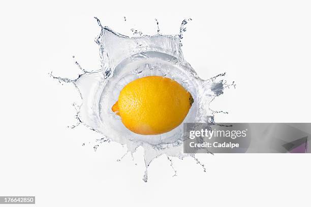 lemon splashing in liquid - cadalpe stock pictures, royalty-free photos & images