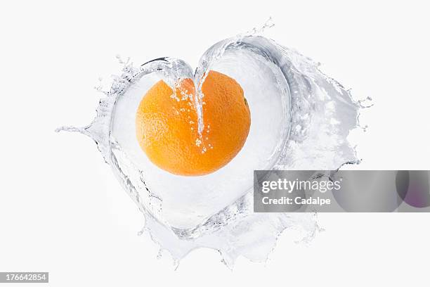 orange splashing in liquid - cadalpe stock pictures, royalty-free photos & images