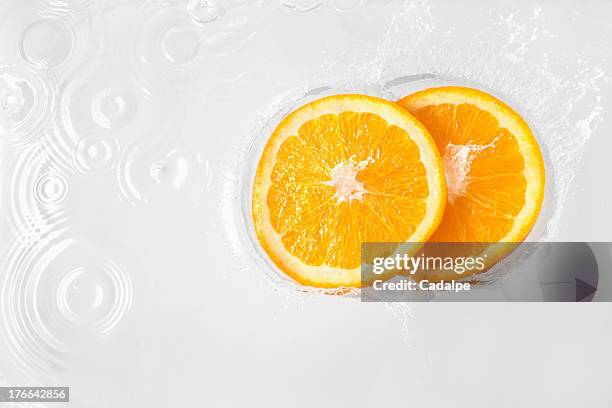 two slices of orange floating in liquid - cadalpe stock pictures, royalty-free photos & images