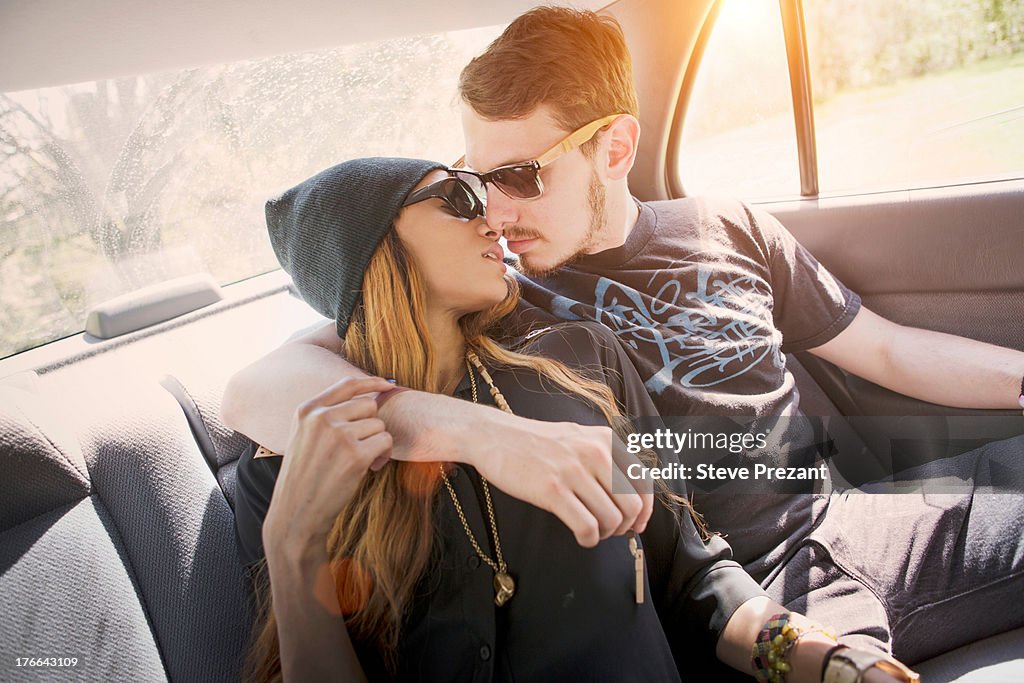 Couple on backseat in car, kissing