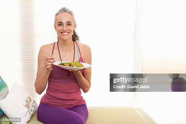 woman sitting on window seat eating lunch, portrait - david swallow stock pictures, royalty-free photos & images