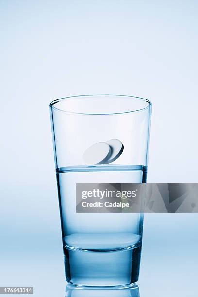 tablets falling in glass of water - cadalpe stock pictures, royalty-free photos & images