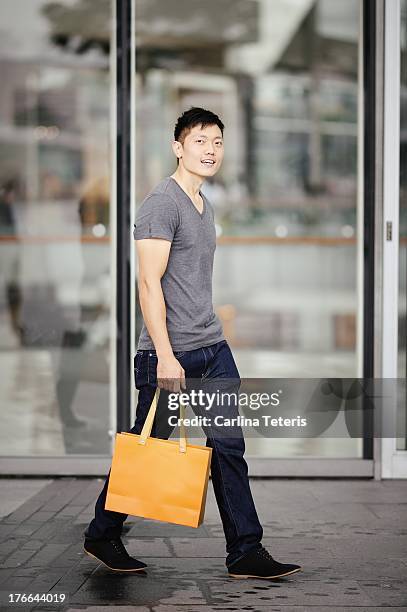 a man walks in front of a mall - singapore man portrait fotografías e imágenes de stock