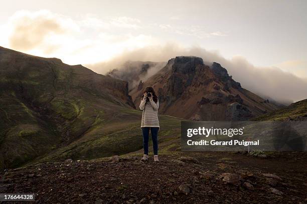 girl taking a picture in front in the mountains - in front of camera stock pictures, royalty-free photos & images