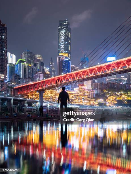 chongqing cyberpunk skyline with reflected person silhouette - chongqing stock pictures, royalty-free photos & images