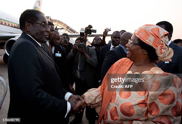 Malawi President Joyce Banda welcomes Zimbabwean President Robert Mugabe at the Kamuzu International Airport in Lilongwe, on August 16 ahead of the...