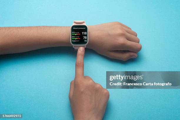 woman's hands checking heart rate on smart watch - smartwatch stock-fotos und bilder