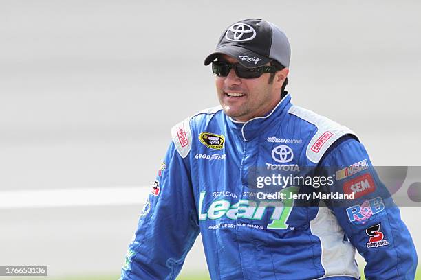 David Stremme, driver of the Lean1 Toyota, walks on the grid during qualifying for the NASCAR Sprint Cup Series 44th Annual Pure Michigan 400 at...