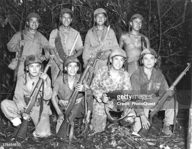 Group portrait showing Navajo Indians skilled in the native lore of their ancestors who are serving with a Marine Signal Unit in Bougainville, during...