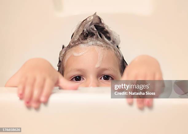 little girl peeking over tge bathtub - child washing hands stock pictures, royalty-free photos & images