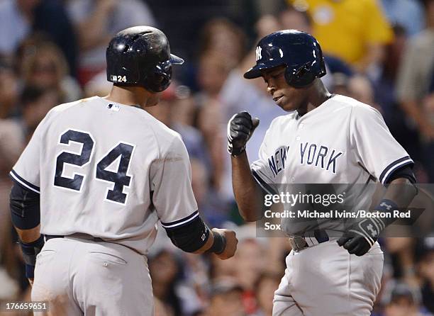 Alfonso Soriano of the New York Yankees is congratulated by Robinson Cano after hitting a home run against the Boston Red Sox in the third inning on...