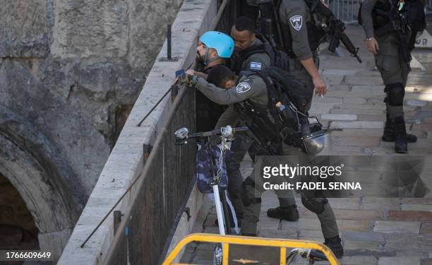 Israeli border police forces inspect people entering annexed east Jerusalem through Damascus Gate after a female member of the Israeli security...
