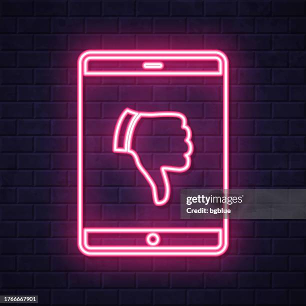 tablet pc with thumbs down. glowing neon icon on brick wall background - touch screen wall stock illustrations