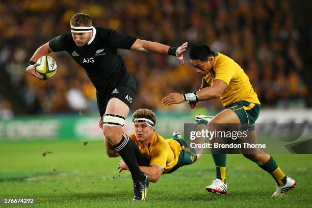 Kieran Read of the All Blacks breaks the tackle of Michael Hooper and Christian Lealiifano of the Wallabies during The Rugby Championship Bledisloe...