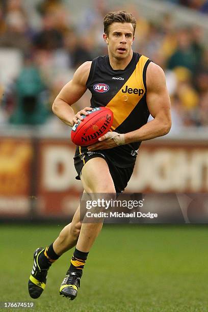 Brett Deledio of the Tigers runs with the ball during the round 21 AFL match between the Richmond Tigers and the Carlton Blues at Melbourne Cricket...