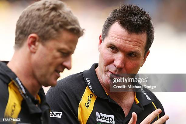 Tigers coach Damien Hardwick liestens to assistant coach Wayne Campbell during the round 21 AFL match between the Richmond Tigers and the Carlton...