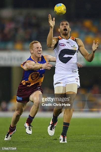 Curtly Hampton of the Giants is tackled by Josh Green of the Lions during the round 21 AFL match between the Brisbane Lions and the Greater Western...