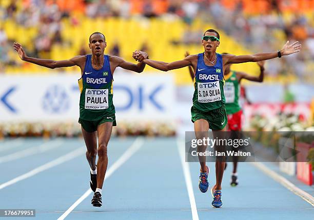 Paulo Roberto Paula of Brazil and Solonei da Silva of Brazil hold hands as they cross the finish line in the Men's Marathon during Day Eight of the...