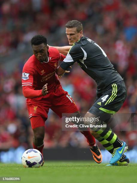 Daniel Sturridge of Liverpool attempts to move away from Robert Huth of Stoke City during the Barclays Premier League match between Liverpool and...