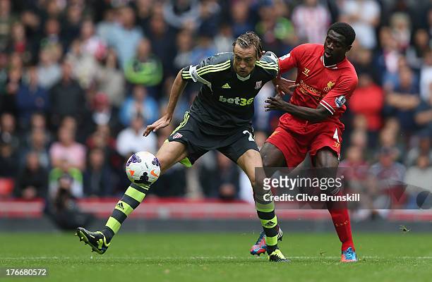 Peter Crouch of Stoke City holds off a challenge from Kolo Toure of Liverpool during the Barclays Premier League match between Liverpool and Stoke...