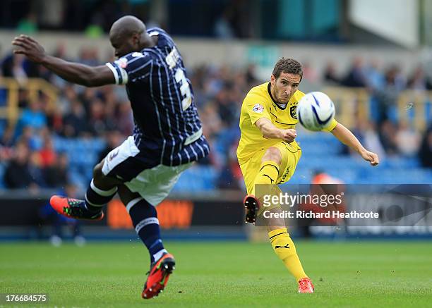 Martin Paterson of Huddersfield fires in a shot around Danny Shittu of Millwall during the Sky Bet Championship match between Millwall and...