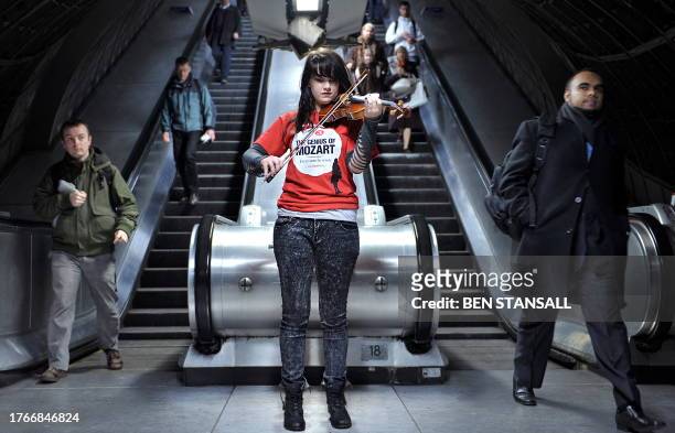 Musician Olivia Shotton plays the violin for commuters at Waterloo's underground train station in London, on January 4 during a photocall to promote...