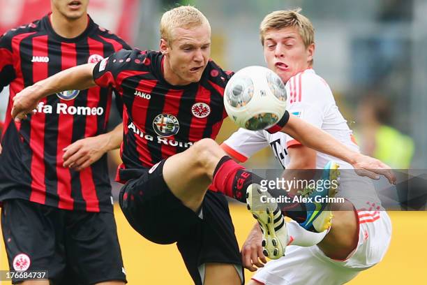 Sebastian Rode of Frankfurt is challenged by Toni Kroos of Muenchen during the Bundesliga match between Eintracht Frankfurt and FC Bayern Muenchen at...