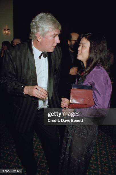 English comedian Peter Cook and partner Chiew Lin Chong at the Theatre Royal for the play 'Silly Cow', London, circa 1991.