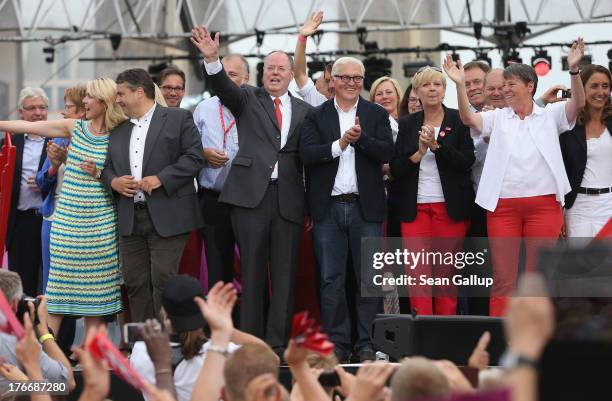 German Social Democrats chancellor candidate Peer Steinbrueck waves to supporters while standing on stage with other leading party members, including...