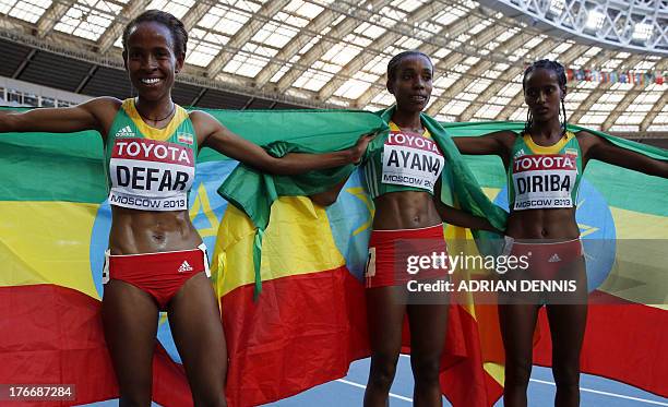 Winner Ethiopia's Meseret Defar, third placed Ethiopia's Almaz Ayana and Ethiopia's Buze Diriba celebrate after the women's 5000 metres final at the...