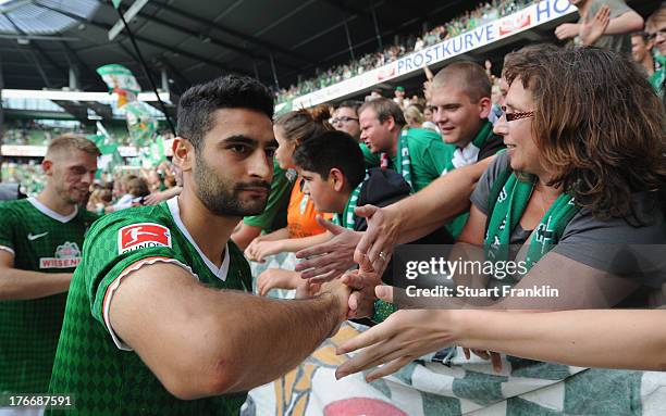 Mehmet Ekici of Bremen celebrates with fans after the Bundesliga match between Werder Bremen and FC Augsburg at Weserstadion on August 17, 2013 in...