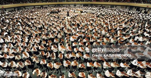 Children play the violin at the 52th Suzuki Method Grand Concert as part of the graduation ceremony for the music school in Tokyo on March 30, 2009....