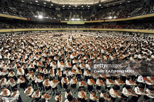 Children play the violin at the 52th Suzuki Method Grand Concert as part of the graduation ceremony for the music school in Tokyo on March 30, 2009....