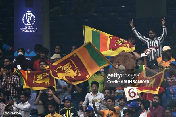 Fans wave Sri Lanka's national flags during the 2023 ICC Men's Cricket World Cup one-day international match between Bangladesh and Sri Lanka at the...