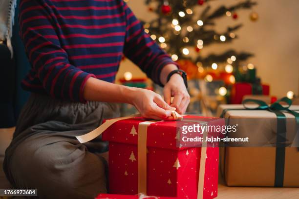 primer plano de una mujer envolviendo regalos para navidad. - maple tree fotografías e imágenes de stock