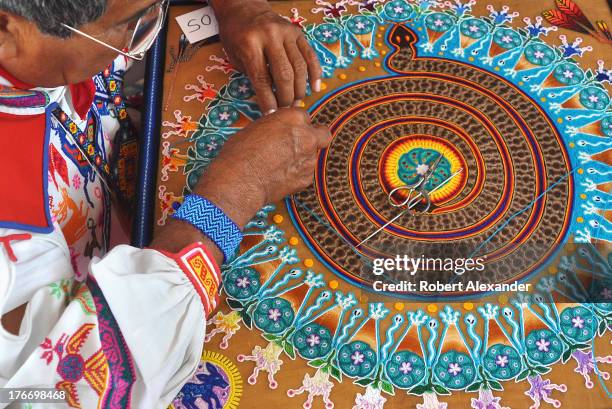 Huichol Indian yarn painter Mariano Navarro from Mexico demonstrates his art at the International Folk Art Market in Santa Fe, New Mexico. The...