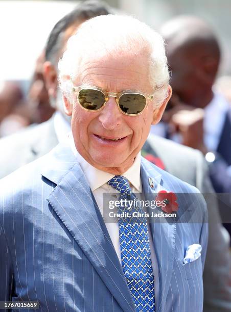 King Charles III smiles as he arrives with Queen Camilla for their separate engagements inside Eastlands Library, where the King will join young...