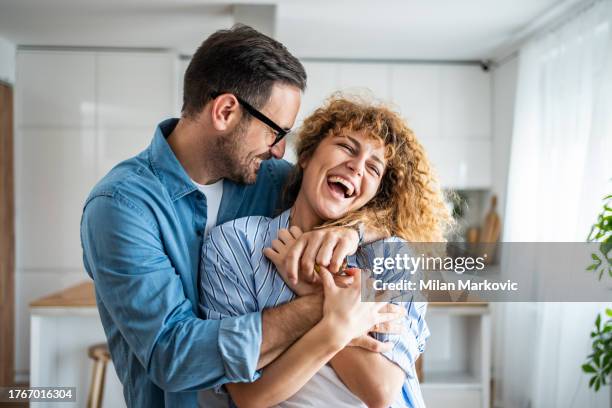 a wonderful scene of love and happiness between a couple in love enjoying their new apartment - relatie stockfoto's en -beelden