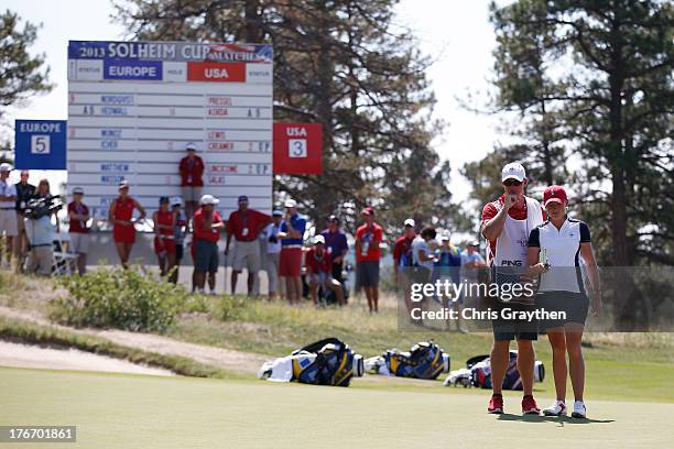 Stacy Lewis of the United States Team and her caddy Travis Wilson line up a putt on the 13th hole during the monring Foursome matches for the 2013...