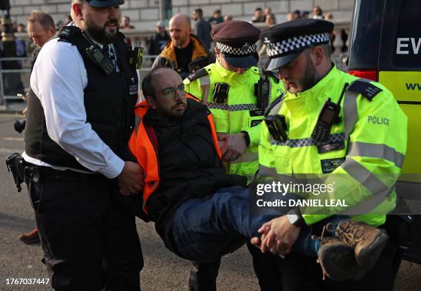 Just Stop Oil climate activist is arrested by Metropolitan Police officers after taking part in a slow march to disrupt traffic, on Whitehall in...