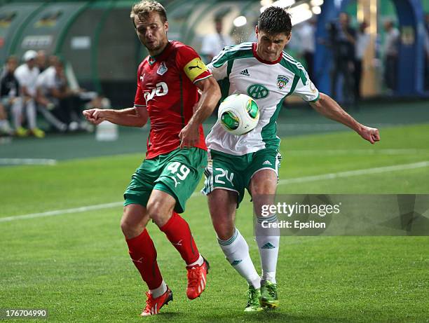 Marcin Komorowski of FC Terek Grozny is challenged by Roman Shishkin of FC Lokomotiv Moscow during the Russian Premier League match between FC Terek...